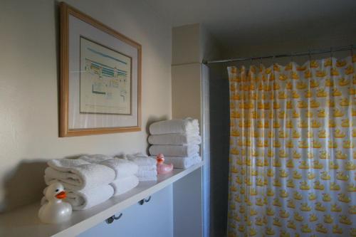 拉古纳海滩The Tides Laguna Beach的浴室设有架子上的毛巾和淋浴。