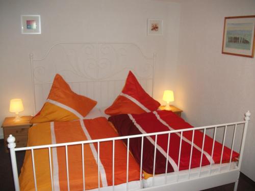 巴特Ostseeurlaub-Barth的一张带橙色和橙色枕头的床
