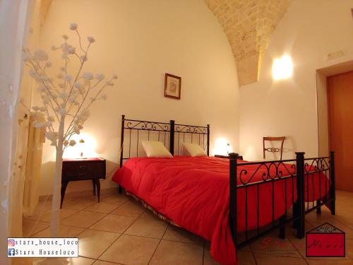 洛科罗通多Stars House的一间卧室配有一张红色床罩的床