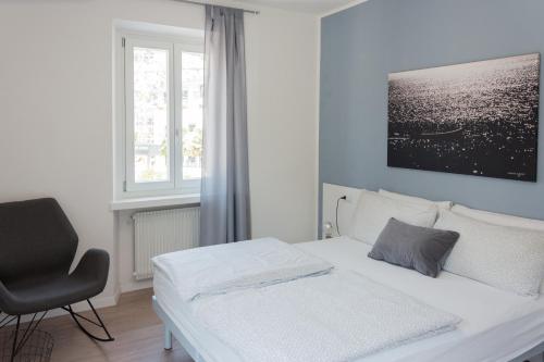 托尔博莱Nirvana Apartments的卧室配有白色的床和椅子