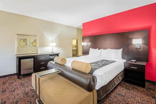 埃尔克城埃尔克城拉金塔旅馆及套房的一张位于酒店客房的大床,设有红色的墙壁