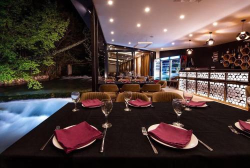 佩奇Resort Ujevara e Drinit的一张桌子,上面放有酒杯和餐巾