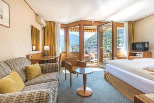 卢加诺Hotel Delfino Lugano的酒店客房,配有床和沙发