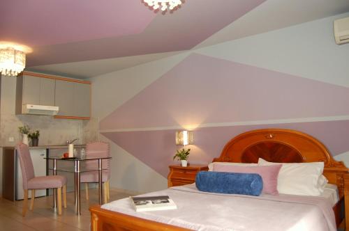 波罗斯ALKYONI Studios Poros Kefalonia的一间卧室配有一张床铺和一张桌子,还设有一间厨房