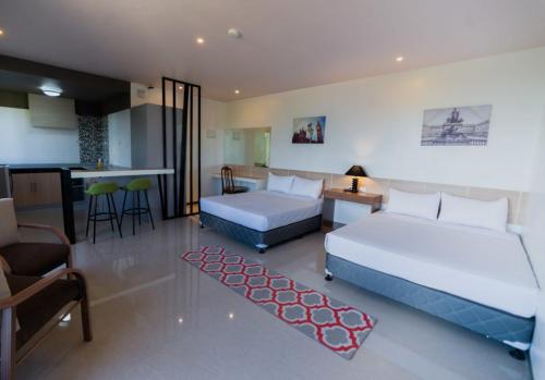 TalibonSoi Suites的酒店客房设有两张床、一个厨房和一个厨房。