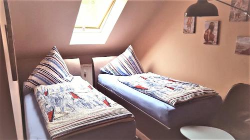 卡尔斯哈根Ferienwohnung Jamie的客房设有两张带枕头的床和窗户。