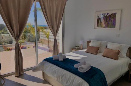 帕福斯Sophia's Seaview Luxury Villas的一间卧室设有一张大床和一个大窗户