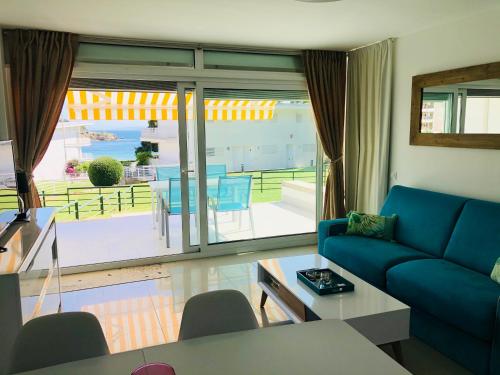 罗萨斯Almadrava Beach的一间带蓝色沙发的客厅和一个阳台