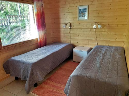 普马拉Lappalaisen lomamökit Mäntypirtti的一间卧室设有两张床和窗户。
