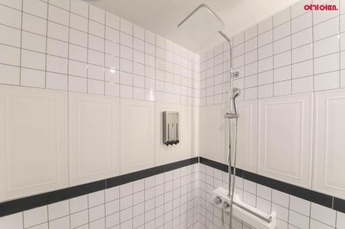 光州Hotel Yeogijoa的带淋浴的浴室和白色瓷砖墙壁