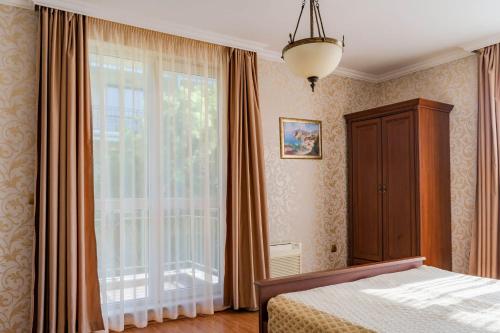 圣君士坦丁和海伦那锦绣复式公寓的一间卧室设有一张床和一个大窗户