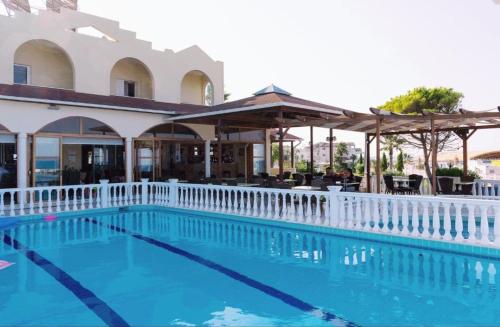 卡纳里奥卡特琳娜酒店的一座游泳池,四周环绕着一座建筑,设有白色的围栏
