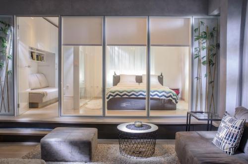 萨格勒布马克西米1号苏伯公寓的卧室配有玻璃墙内的一张床