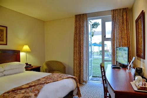 乔治Town Lodge George的配有一张床、一张书桌和一扇窗户的酒店客房