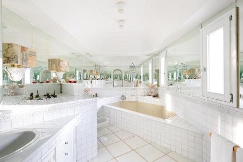 伊斯基亚Luxury Relais Villa Magdalena的白色的浴室设有2个盥洗盆和1个浴缸。