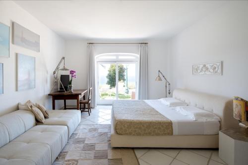 伊斯基亚Luxury Relais Villa Magdalena的白色卧室配有床和沙发