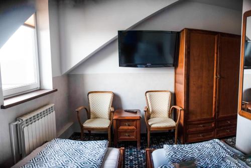 KroczyceStacja Jura的一间带两把椅子和一张床的卧室以及一台电视