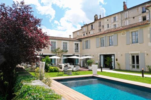 昂古莱姆Hotel Le Saint Gelais的建筑前带游泳池的庭院