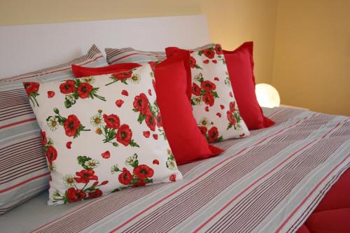 卡尔达诺阿尔坎波Le Margherite的一张带红色和白色枕头的床
