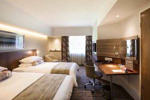开普敦City Lodge Hotel Pinelands的酒店客房配有两张床和一张书桌