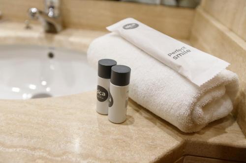 圣地亚哥－德孔波斯特拉Oca Puerta del Camino Hotel的浴室提供毛巾和2瓶台面