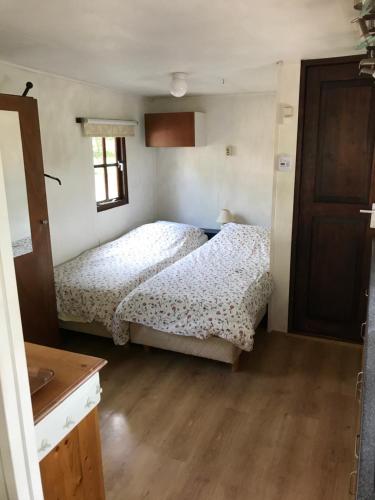 WinsumChalet westerham的一间卧室设有两张床,铺有木地板