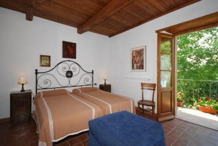 塞吉阿诺Agriturismo Ombianco的一间卧室设有一张床和一个大窗户