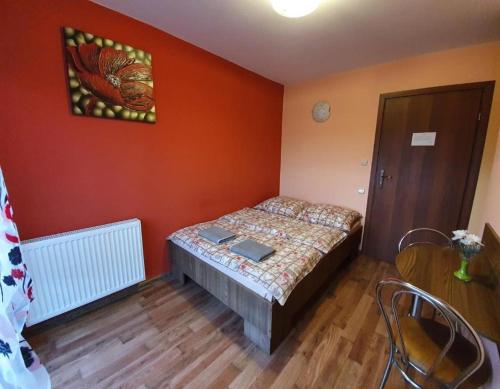 AlbigowaAlbinos的一间设有床铺的卧室,位于一个拥有橙色墙壁的房间