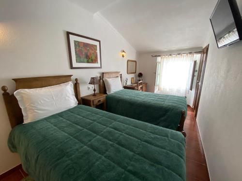 马尔旺阿连特茹阳台旅馆的酒店客房,配有两张带绿床单的床