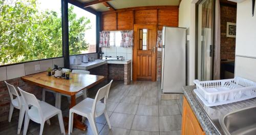 科尔切斯特Palm Cottage - Colchester - 5km from Elephant Park的厨房配有桌子和冰箱