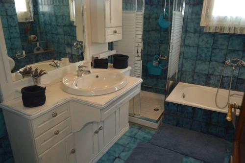 沃洛斯Triple H的浴室配有水槽、淋浴和浴缸。