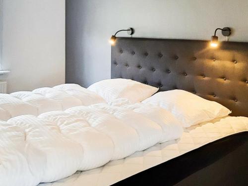 斯卡恩Holiday home Skagen XXX的一张配有白色床单和枕头的大床