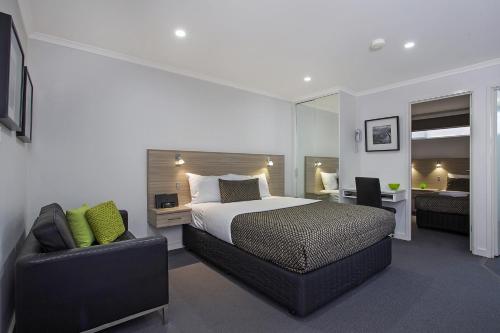 汉密尔顿汉密尔顿朗斯代尔汽车旅馆的一间卧室配有一张床、一张沙发和一把椅子