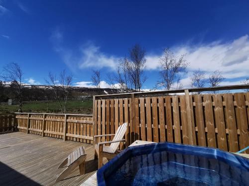 阿克雷里Hotel Kjarnalundur- Aurora Dream - Lodges and Rooms的木栅栏旁甲板上的热水浴池