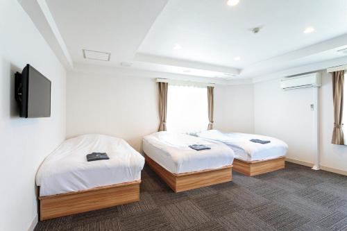 埼玉市威尔斯特酒店的客房设有两张床和一台平面电视。
