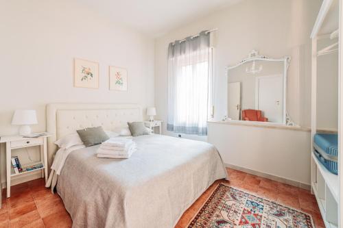 陶尔米纳B&B Greco Home的白色卧室设有一张大床和镜子