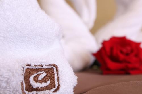 奥布佐尔卡萨布兰卡全包酒店的一条毛巾,上面写着c字母,紧贴着红玫瑰