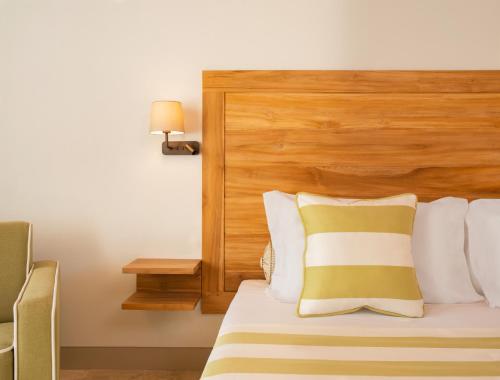 锡罗洛San Michele Relais & Spa的酒店客房,配有一张带木制床头板的床