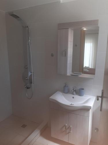 路特奇Aegean View Villa的白色的浴室设有水槽和淋浴。