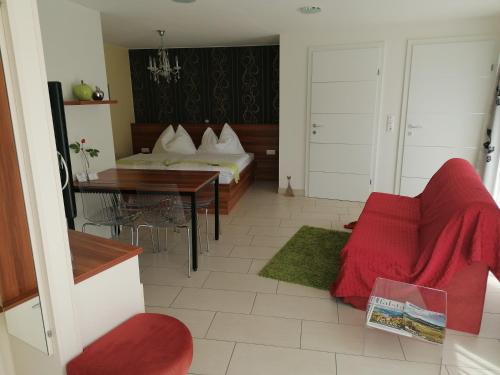 多瑙河畔伊布斯伊布斯花园公寓的客厅配有床和红色沙发