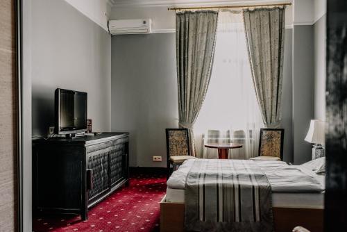 科克舍套Plaza Hotel的一间卧室设有一张床、一台电视和一个窗口。