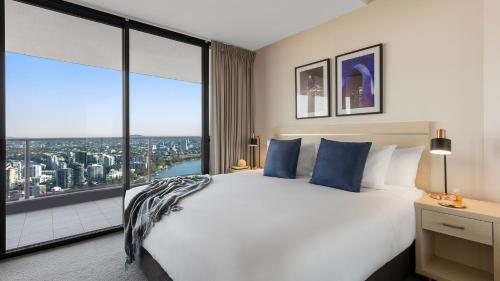 布里斯班Oaks Brisbane Aurora Suites的一间卧室设有一张大床和一个大窗户