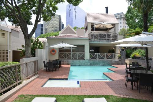 约翰内斯堡Courtyard Hotel Sandton的房屋设有一座带桌椅的游泳池