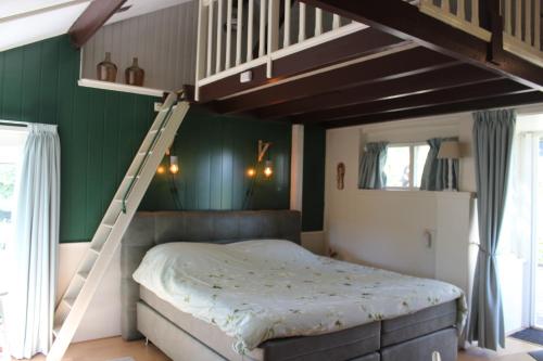 VenhorstB&B Helene Hoeve的一间卧室配有带梯子的双层床