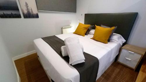 托莱多APARTAMENTOS EL POZO AMARGO的卧室配有一张带黄色枕头的大型白色床。