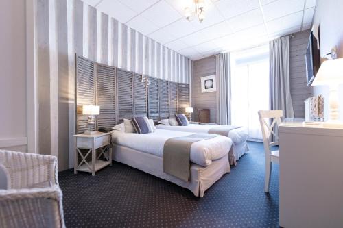 波尔尼谢Cit'Hotel Normandy Hotel Pornichet La Baule的酒店客房,配有两张床和椅子