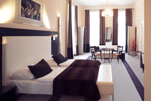 布拉格Old Town Square Residence by Emblem的酒店客房带一张床、一张桌子和椅子
