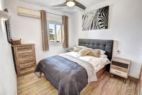 贝纳尔马德纳Benal Beach, Luxury Sea & Mountain View Beachside 1 Bedroom Apartment的卧室配有一张床,墙上挂着斑马图