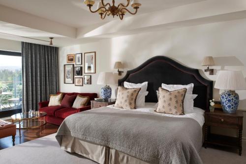 奥赫特拉德格伦伊格尔斯酒店的一间卧室配有一张大床和一张红色的沙发