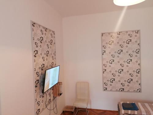 米什科尔茨Kriston Apartman的一间配有电视的房间,墙上挂着一幅画